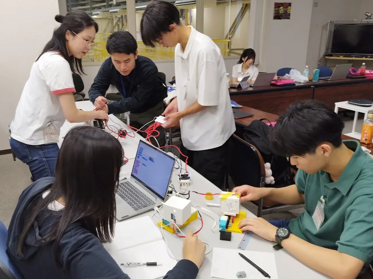 会議室の机で検出器の動作を確認する中高生たち
